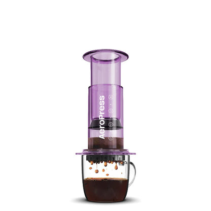 Prensa de café con cilindro morado y base oscura, asa lateral