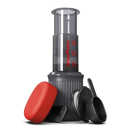 AeroPress GO de mano con cilindro transparente, base acanalada y tapas roja y negra