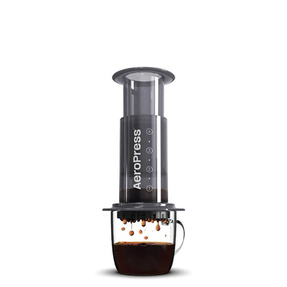 AeroPress de prensa de café con cilindro transparente y base oscura, asa lateral