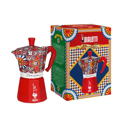 Cafetera moka de aluminio con estampado multicolor y base roja, con asa y tapa rojas