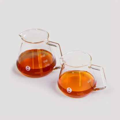 Jarra de café transparente Timemore con asas y marcas, con líquido ámbar