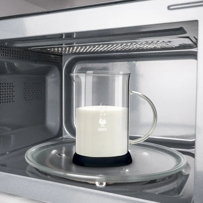 Espumador de leche Bialetti en horno, jarra de acero con espuma blanca.