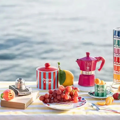 Cafetera italiana Moka Express fucsia sobre mesa, con asa y tapa; 3 tazas