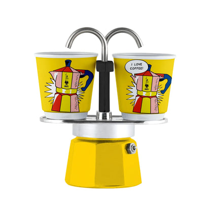 Cafetera moka mini con dos vasos de color amarillo, asas curvas y base esmaltada