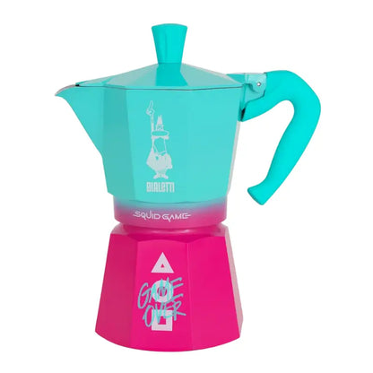Cafetera italiana tipo moka turquesa y magenta, perfil lateral con asa y válvula