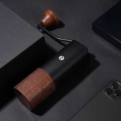 Molino de café negro con base de madera y manivela, vista superior