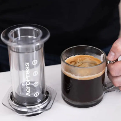 Portafiltro Aeropress con control de flujo y vaso de vidrio durante la preparación