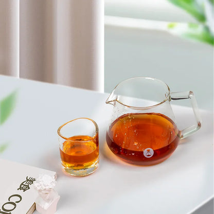 Jarra de café transparente Timemore con asa, con líquido ámbar, y vaso pequeño