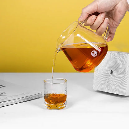 Jarra de café transparente Timemore y vertido de infusión ámbar en vaso pequeño