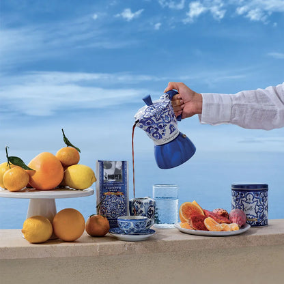 Cafetera moka de inducción azul con estampado Dolce&Gabbana y tazas; estilo Bialetti.