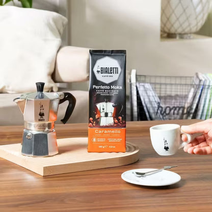 Bolsa de café molido Bialetti Perfecto Moka Caramello sobre mesa, 250 g