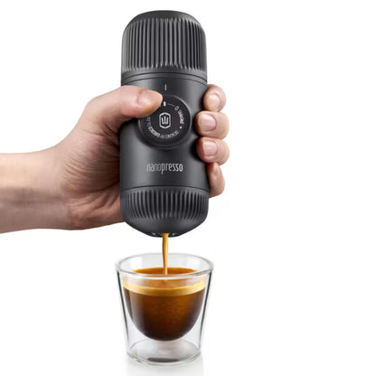 Cafetera portátil negra Nanopresso con café saliendo, vista frontal