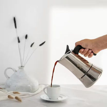 Cafetera italiana de acero Bialetti Moon Exclusive vertiendo café, mango negro