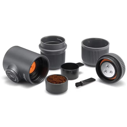 Cafetera portátil negra con accesorios: tazas, portafiltro y herramienta