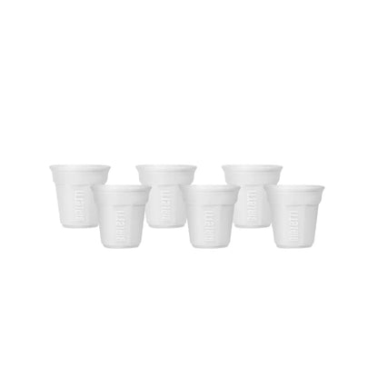Set de 6 vasos de cerámica para espresso en blanco, dispuestos en fila.