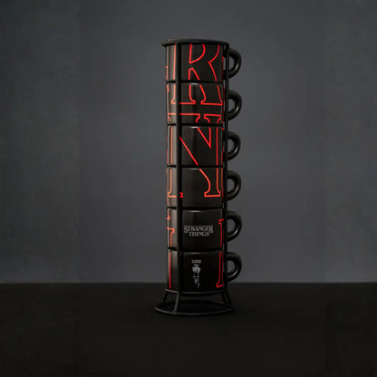 Torre de tazas apilables negras con gráficos rojos y asas, soporte metálico