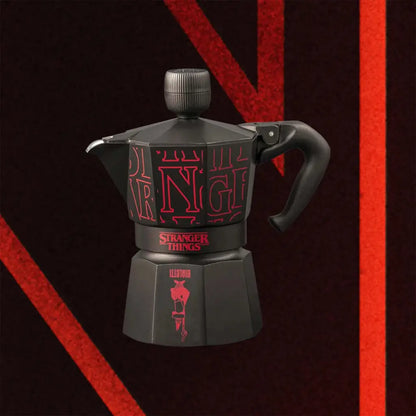 Cafetera moka negra Stranger Things con asa curva y dibujo rojo al centro.