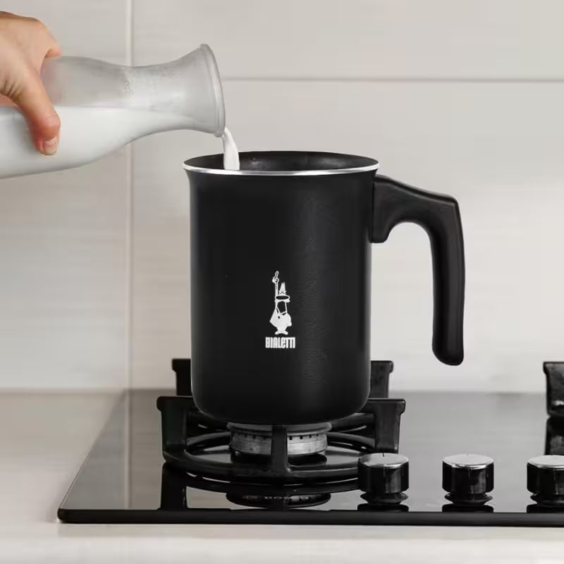 Espumador de leche Bialetti negro, vertiendo leche en jarra con asa