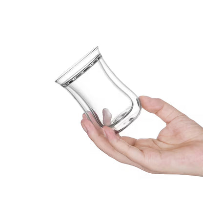 Vaso turco de vidrio doble pared de 80 ml inclinado, sostenido con la mano