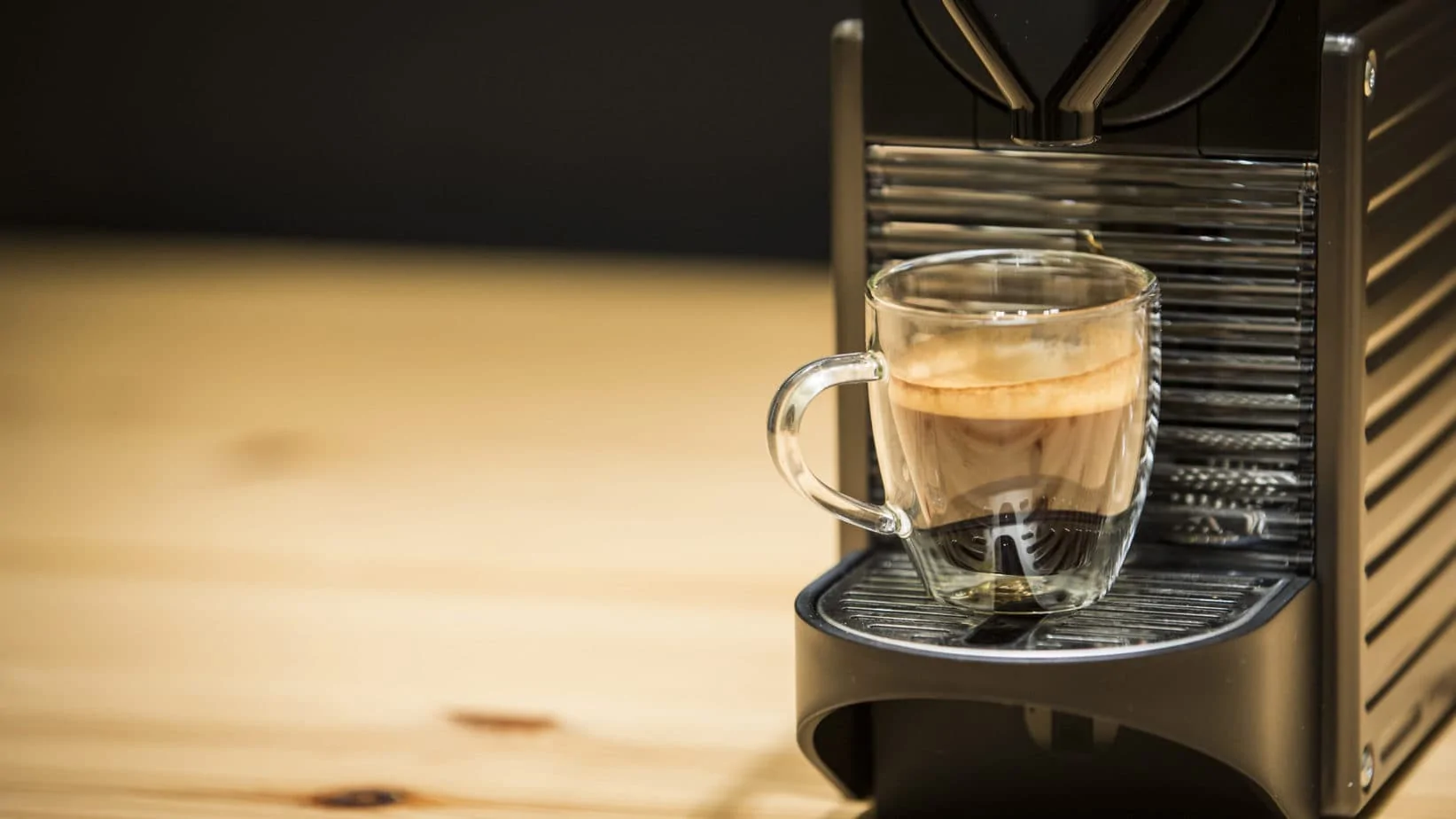 Máquina Nespresso con un cafpe recipen servido.