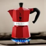 Cafetera Moka Express de color rojo sobre la cocina, perfecta para preparar 3 tazas 130ml de espresso italiano en casa.
