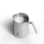 Jarra de leche de acero inoxidable Bialetti llena de leche, con asa y logotipo.
