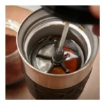 Detalle de la malla del Mug Prensa Francesa de acero inoxidable con tapa negra, ideal para café o té en movimiento, mantiene la temperatura y es fácil de limpiar.