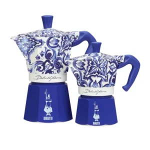 Dos cafeteras moka Bialetti de Dolce&Gabbana, en azul y blanco, con diseños artesanales inspirados en el Mediterráneo.