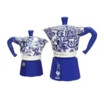 Dos cafeteras moka Bialetti de Dolce&Gabbana, en azul y blanco, con diseños artesanales inspirados en el Mediterráneo.