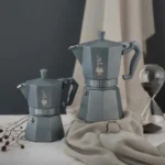 Dos tamaños de cafeteras Italiana Exclusive octogonal de Bialetti sobre una mesa.